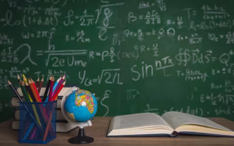 Books and small globe and blackboard on wooden background.