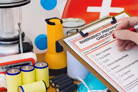 Hand completing Emergency Preparation List by Equipment