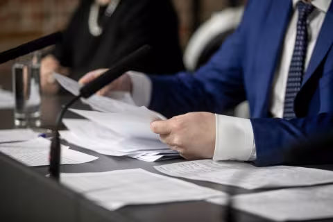 A man in a business suit is holding a pen