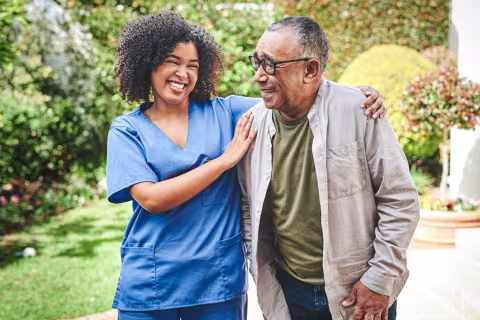 young nurse bonding with her senior patient outside