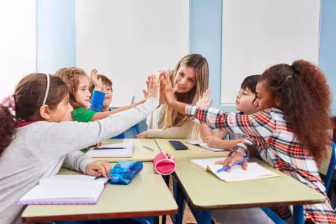 Students of the multicultural school give themselves a high five for integration
