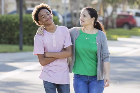 A mother talking to her son while walking across the street